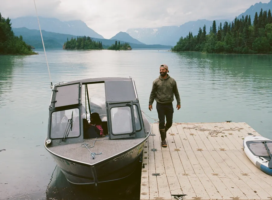 Peter Goodwin, Groove Life founder, in the Alaskan outdoors, walking up a dock from a boat on a lake