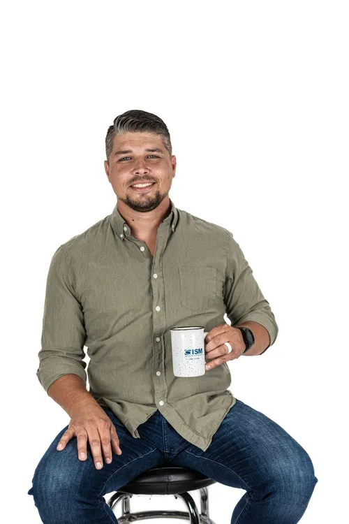 A Groove Life team member on a stool holding a coffee mug